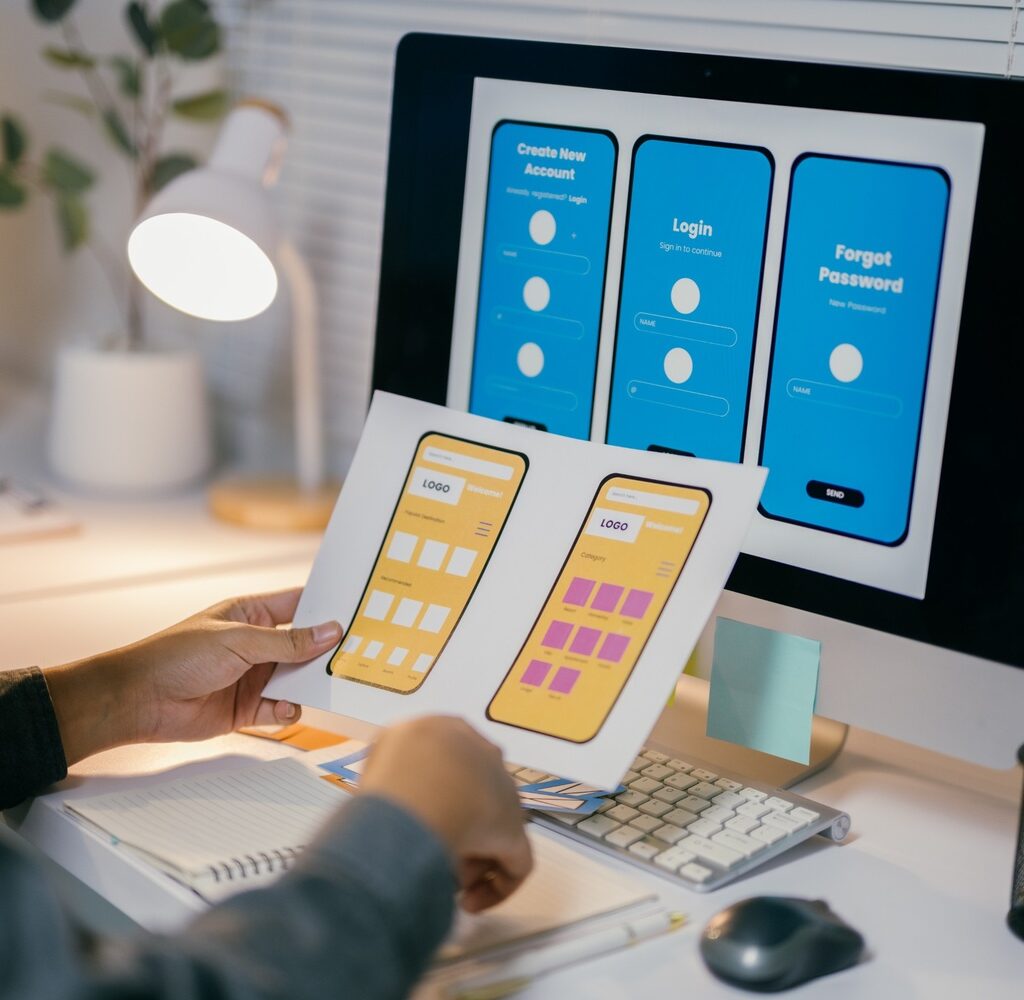 ux designer is reviewing paper prototypes of a mob nlr769m